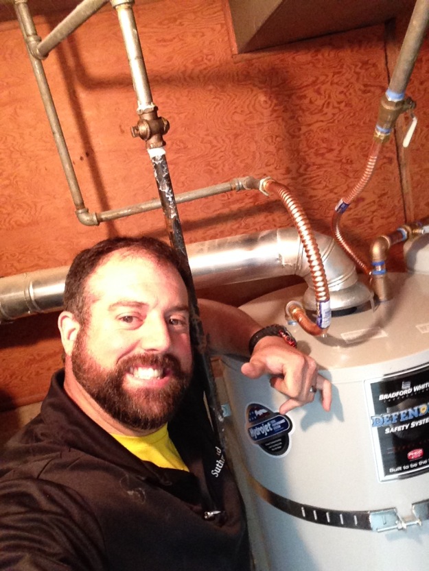 John Benton with one of his newly installed 50 gallon gas water heaters.
